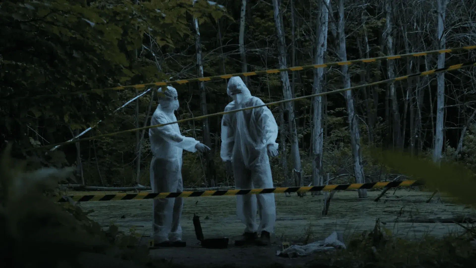Two agents in suits discussing a crime scene.